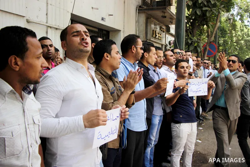 Egyptians Who obtained master's degree hold placards and shout slogans during a protest to demand jobs in Cairo, Egypt, on June 15, 2016. Photo by Amr Sayed