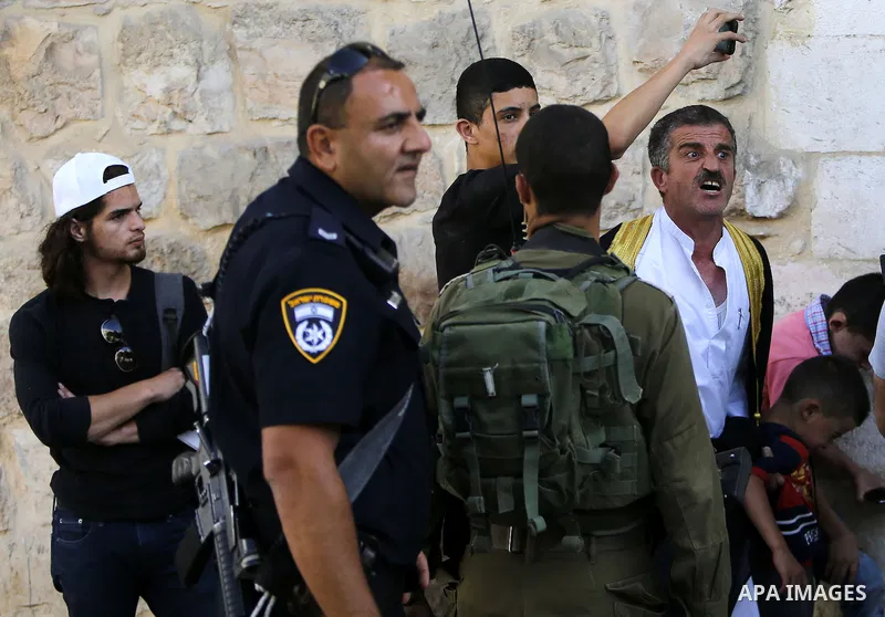 A Palestinian man shouts at Israeli troops after his son was pushed following a protest against the closure of a route used by Palestinians to pass to a school and houses in Shuhada street, in the West Bank city of Hebro...