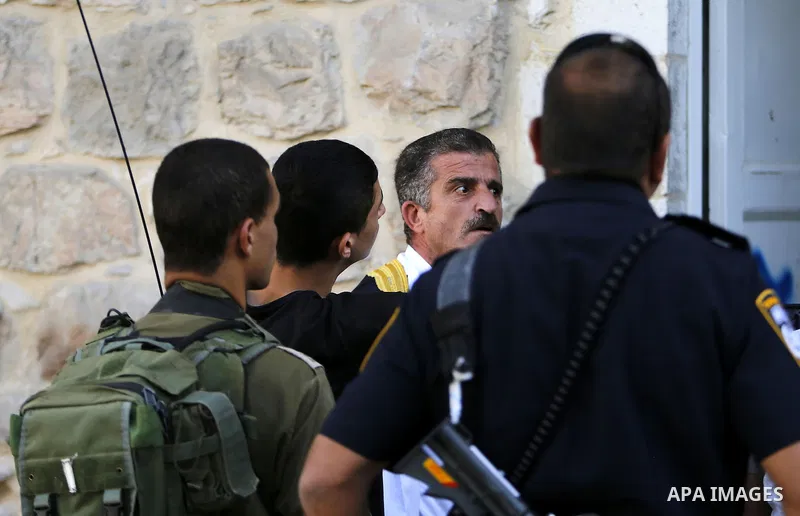 A Palestinian man shouts at Israeli troops after his son was pushed following a protest against the closure of a route used by Palestinians to pass to a school and houses in Shuhada street, in the West Bank city of Hebro...