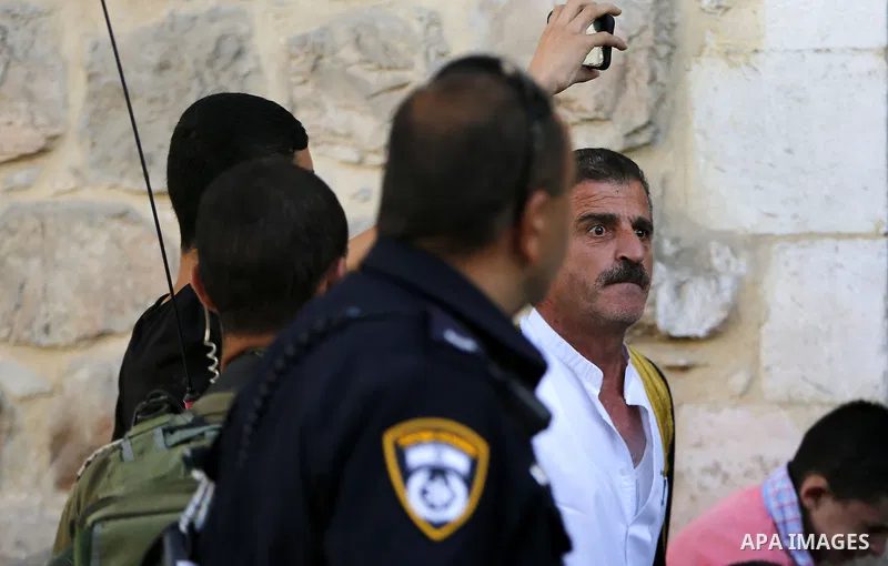 A Palestinian man shouts at Israeli troops after his son was pushed following a protest against the closure of a route used by Palestinians to pass to a school and houses in Shuhada street, in the West Bank city of Hebro...