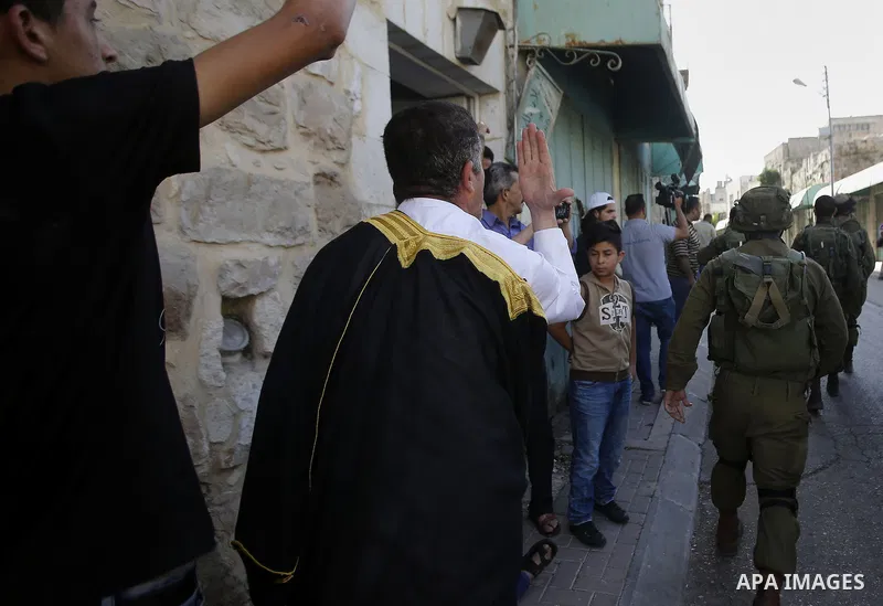 A Palestinian man shouts at Israeli troops after his son was pushed following a protest against the closure of a route used by Palestinians to pass to a school and houses in Shuhada street, in the West Bank city of Hebro...