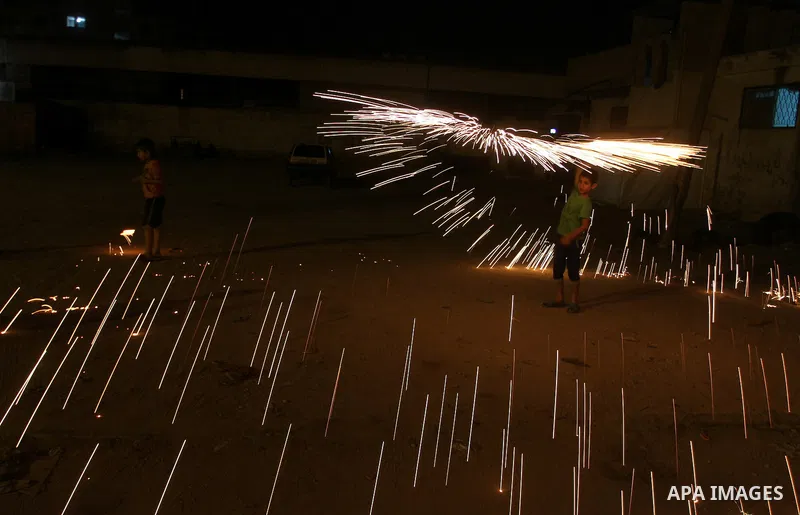 A Palestinian boy plays with fire crackers at street celebrating on the holy month of Ramadan in Rafah in the southern Gaza strip, on June 15, 2016. Ramadan is sacred to Muslims because it is during that month that tradi...