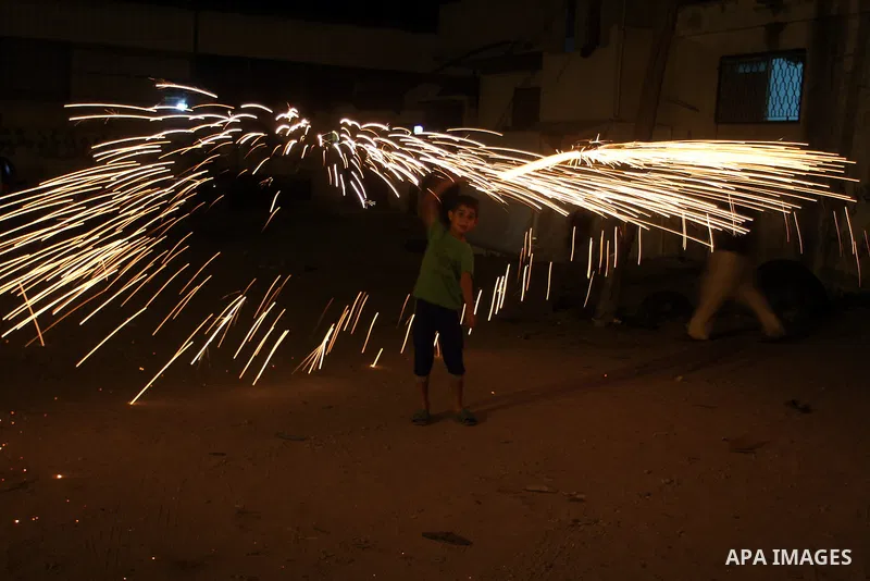 A Palestinian boy plays with fire crackers at street celebrating on the holy month of Ramadan in Rafah in the southern Gaza strip, on June 15, 2016. Ramadan is sacred to Muslims because it is during that month that tradi...