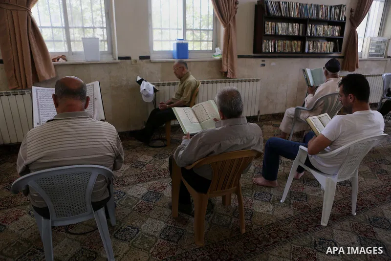 Palestinian Muslim men read the holy Koran, Islam's holy book at a mosque on the holy month of Ramadan in the West bank city of Ramallah, on June 16, 2016. Ramadan is sacred to Muslims because it is during that month tha...