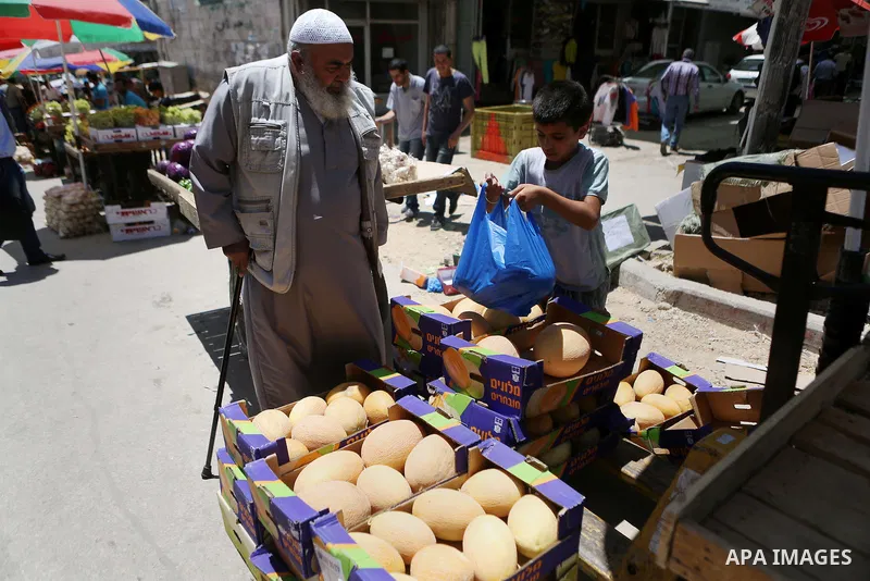 A Palestinian vendor sells fruits at a market on the holy month of Ramadan in the West bank city of Ramallah, on June 16, 2016. Ramadan is sacred to Muslims because it is during that month that tradition says the Koran w...