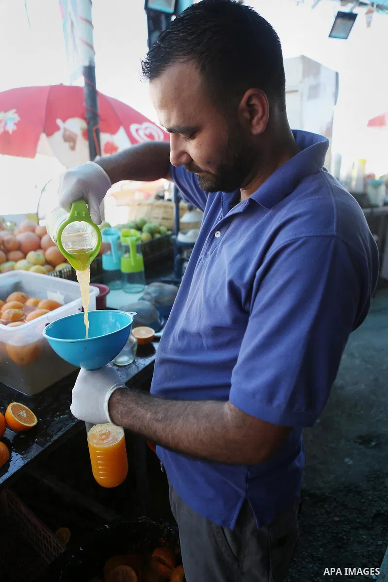 A Palestinian vendor prepares orange juice on the holy month of Ramadan at a market in the West bank city of Ramallah, on June 16, 2016. Ramadan is sacred to Muslims because it is during that month that tradition says th...