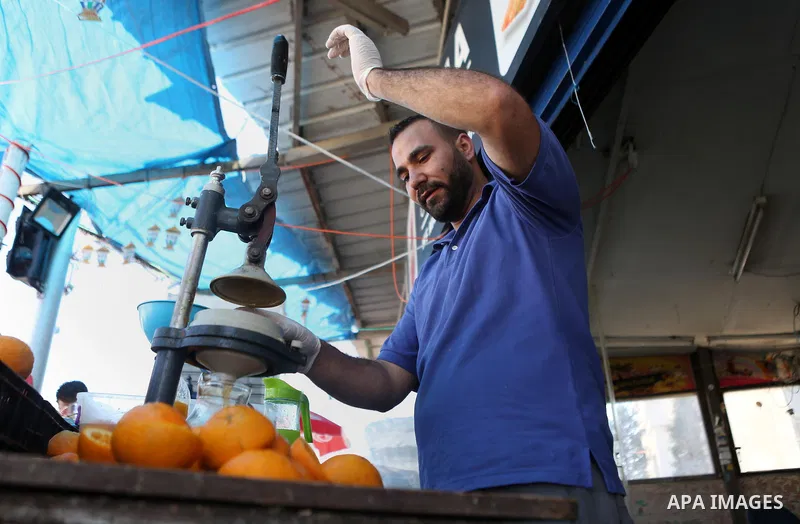 A Palestinian vendor prepares orange juice on the holy month of Ramadan at a market in the West bank city of Ramallah, on June 16, 2016. Ramadan is sacred to Muslims because it is during that month that tradition says th...