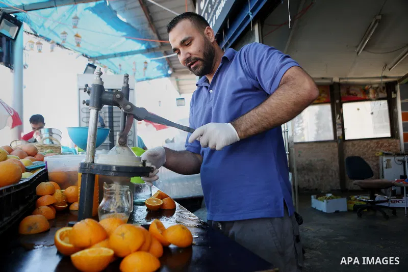 A Palestinian vendor prepares orange juice on the holy month of Ramadan at a market in the West bank city of Ramallah, on June 16, 2016. Ramadan is sacred to Muslims because it is during that month that tradition says th...
