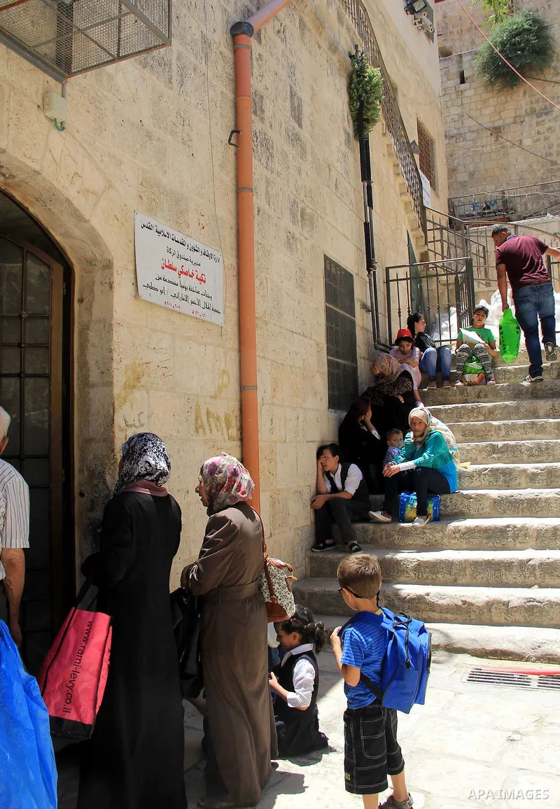 Palestinian families wait to receive a charity meal before the breakfast in the Islamic holy month of Ramadan, in Jerusalem, on June 16, 2016. Muslims around the world celebrate Ramadan, the holy month in the Islamic cal...