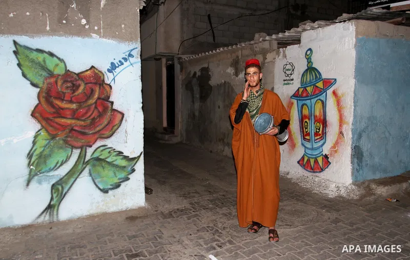 A Palestinian dawn awakener ''al-Musaharati'' walks through streets to wake up Muslims for a meal before sunrise during the fasting month of Ramadan, in Rafah in the southern Gaza strip on June 17, 2016. Al-Musaharati is...