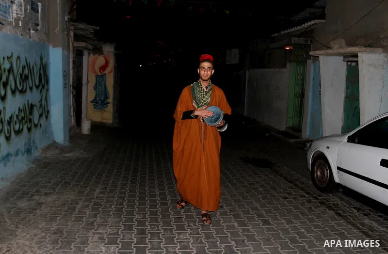 A Palestinian dawn awakener ''al-Musaharati'' walks through streets to wake up Muslims for a meal before sunrise during the fasting month of Ramadan, in Rafah in the southern Gaza strip on June 17, 2016. Al-Musaharati is...