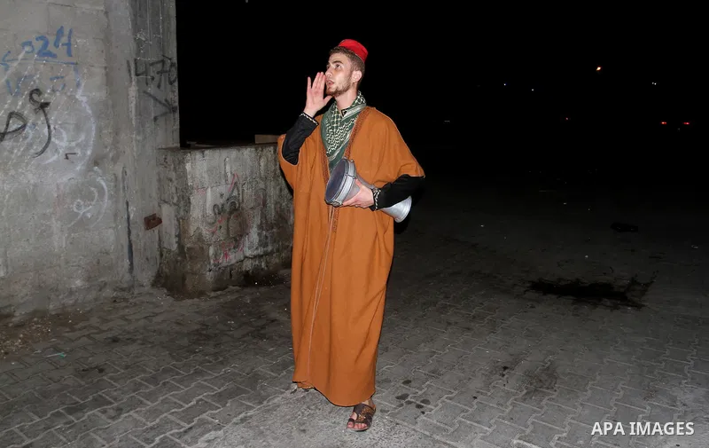 A Palestinian dawn awakener ''al-Musaharati'' walks through streets to wake up Muslims for a meal before sunrise during the fasting month of Ramadan, in Rafah in the southern Gaza strip on June 17, 2016. Al-Musaharati is...