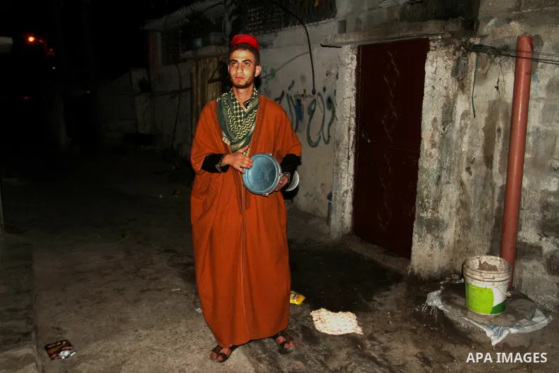 A Palestinian dawn awakener ''al-Musaharati'' walks through streets to wake up Muslims for a meal before sunrise during the fasting month of Ramadan, in Rafah in the southern Gaza strip on June 17, 2016. Al-Musaharati is...
