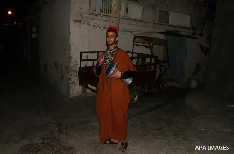 A Palestinian dawn awakener ''al-Musaharati'' walks through streets to wake up Muslims for a meal before sunrise during the fasting month of Ramadan, in Rafah in the southern Gaza strip on June 17, 2016. Al-Musaharati is...