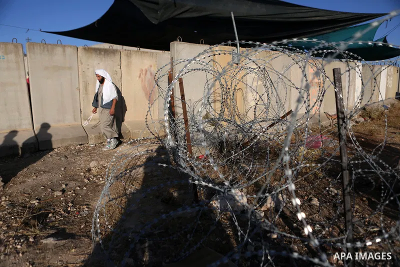 Palestinian men walk past Qalandia checkpoint between the West Bank city of Ramallah and Jerusalem on June 17, 2016, as they head to Jerusalem's Al-Aqsa mosque for the second Friday prayer of the holy Muslim fasting mont...