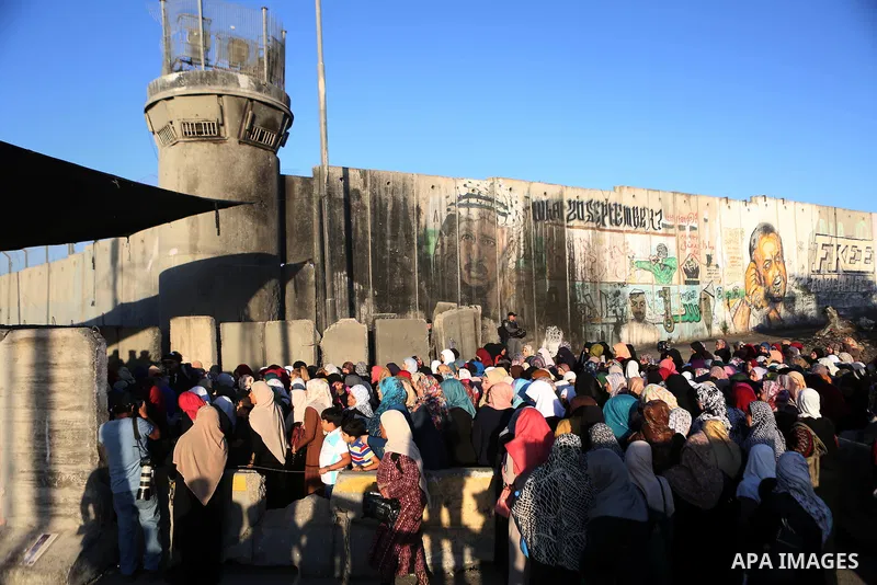 Palestinian women wait to cross the Qalandia checkpoint between the West Bank city of Ramallah and Jerusalem on June 17, 2016, as they head to Jerusalem's Al-Aqsa mosque for the second Friday prayer of the holy Muslim fa...