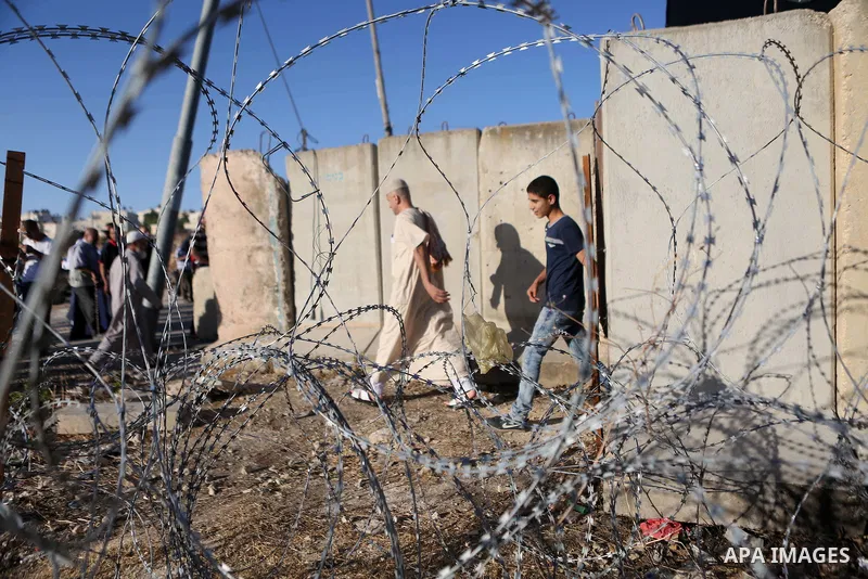 Palestinian men walk past Qalandia checkpoint between the West Bank city of Ramallah and Jerusalem on June 17, 2016, as they head to Jerusalem's Al-Aqsa mosque for the second Friday prayer of the holy Muslim fasting mont...