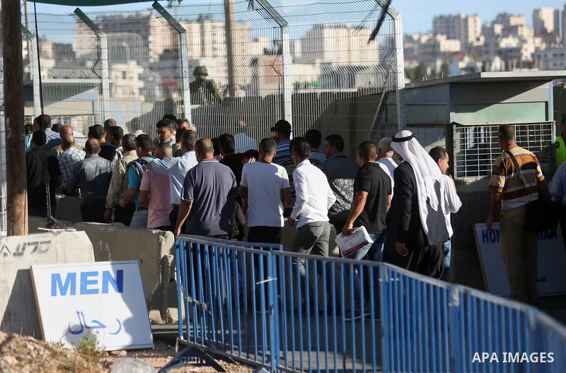 Palestinian men wait to cross the Qalandia checkpoint between the West Bank city of Ramallah and Jerusalem on June 17, 2016, as they head to Jerusalem's Al-Aqsa mosque for the second Friday prayer of the holy Muslim fast...