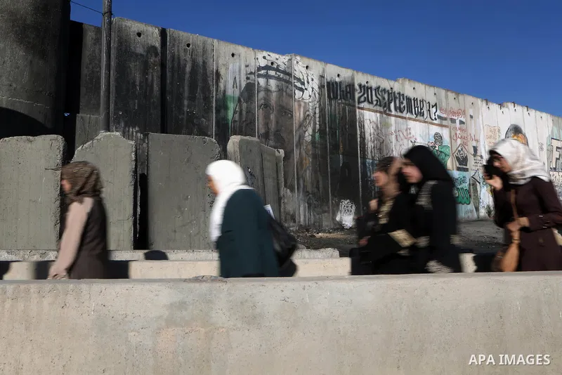 Palestinian women wait to cross the Qalandia checkpoint between the West Bank city of Ramallah and Jerusalem on June 17, 2016, as they head to Jerusalem's Al-Aqsa mosque for the second Friday prayer of the holy Muslim fa...