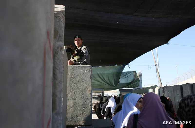 Palestinian women wait to cross the Qalandia checkpoint between the West Bank city of Ramallah and Jerusalem on June 17, 2016, as they head to Jerusalem's Al-Aqsa mosque for the second Friday prayer of the holy Muslim fa...
