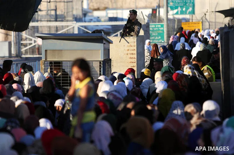 Palestinian women wait to cross the Qalandia checkpoint between the West Bank city of Ramallah and Jerusalem on June 17, 2016, as they head to Jerusalem's Al-Aqsa mosque for the second Friday prayer of the holy Muslim fa...