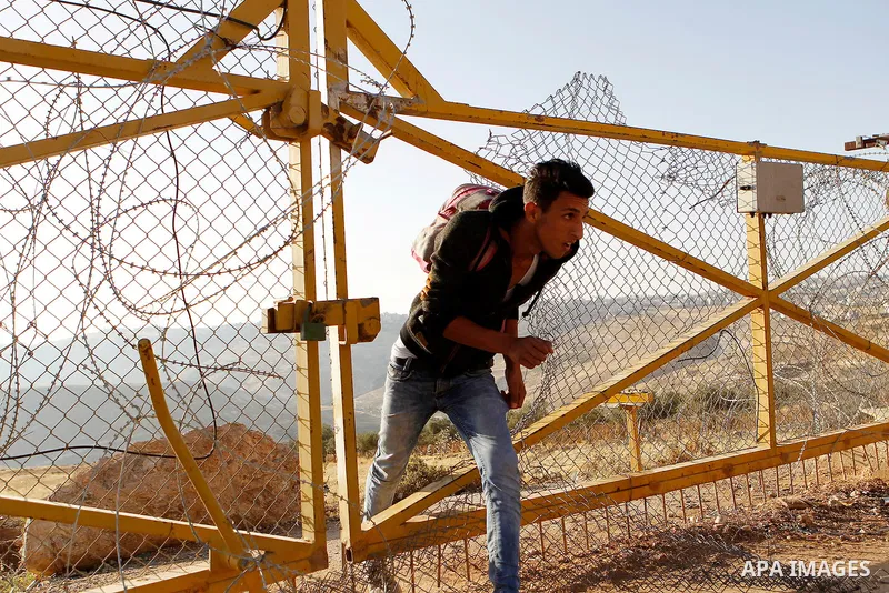 Palestinians, not permitted by Israeli security forces to cross into Jerusalem from the West Bank due to an age limit, climb an Israeli fence between the West Bank town of Bethlehem and Jerusalem as they try to make thei...