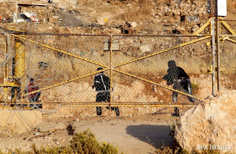 Palestinians, not permitted by Israeli security forces to cross into Jerusalem from the West Bank due to an age limit, climb an Israeli fence between the West Bank town of Bethlehem and Jerusalem as they try to make thei...