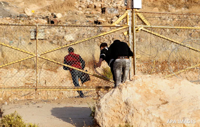 Palestinians, not permitted by Israeli security forces to cross into Jerusalem from the West Bank due to an age limit, climb an Israeli fence between the West Bank town of Bethlehem and Jerusalem as they try to make thei...