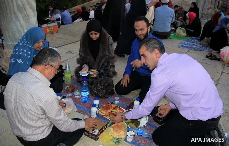 Palestinian muslims take their breakfast during the holy fasting month of Ramadan in front of the Dome of the Rock mosque at the al-Aqsa mosque compound in Jerusalem's old city on June 17, 2016 during the holy fasting mo...