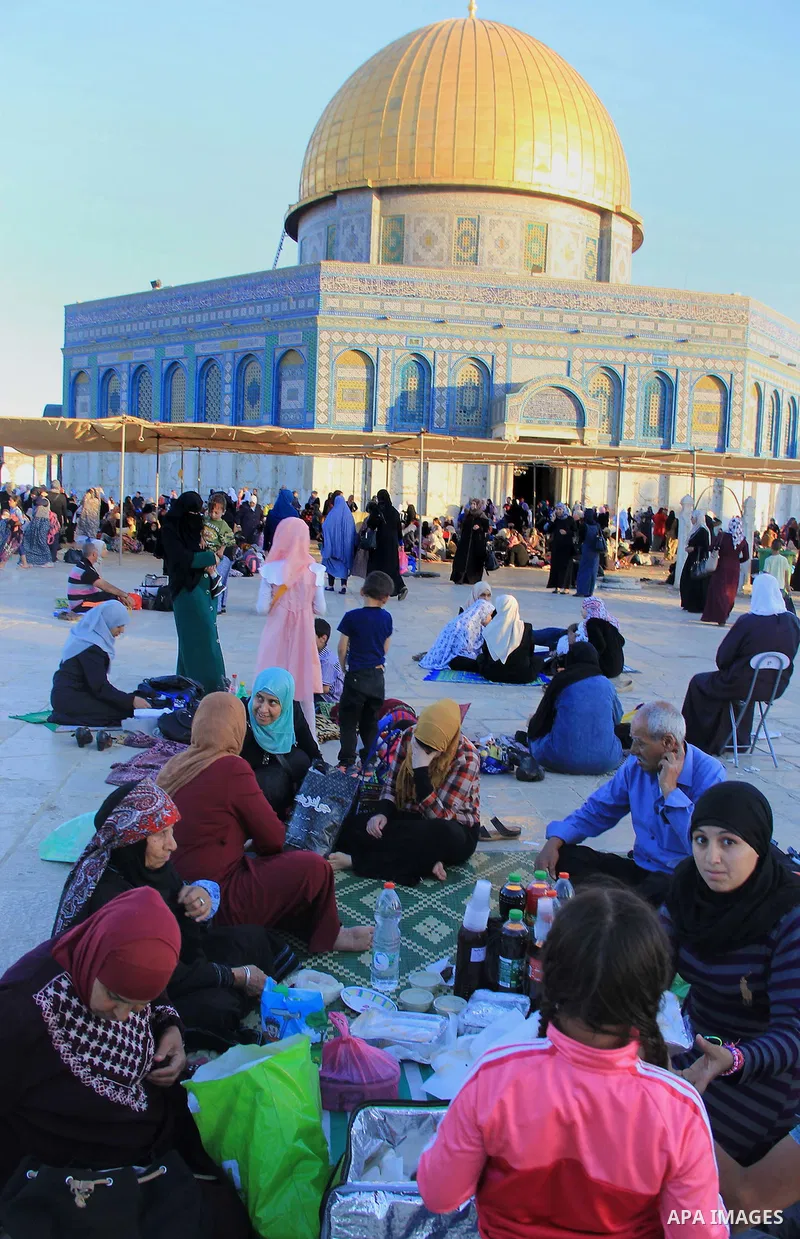 Palestinian muslims take their breakfast during the holy fasting month of Ramadan in front of the Dome of the Rock mosque at the al-Aqsa mosque compound in Jerusalem's old city on June 17, 2016 during the holy fasting mo...