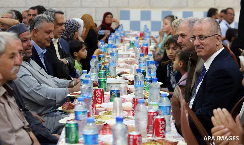 Palestinian Prime Minister Rami Hamdallah takes part during take breakfast for orphans on holy fasting month of Ramadan, in the West Bank city of Tulkarem, on June 18, 2016. Photo by Prime Minister Office
