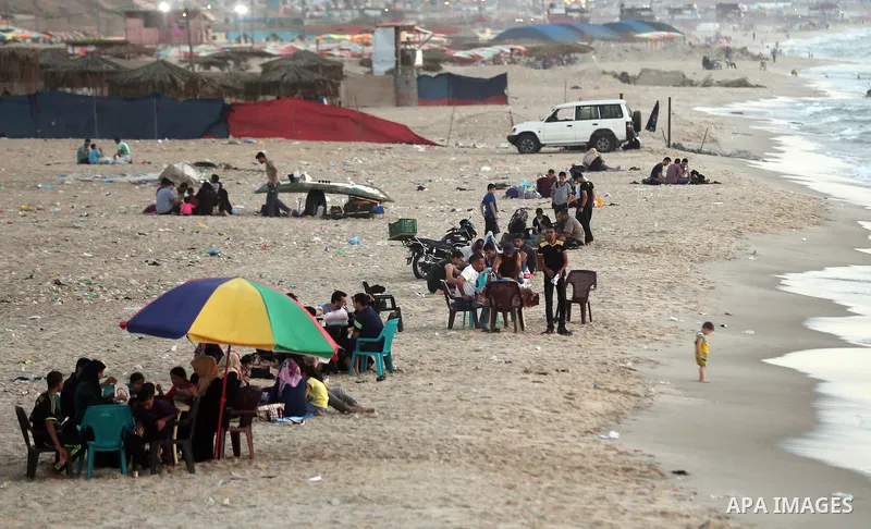 Palestinian Muslims eat their Iftar meal as they break their fast during the holy fasting month of Ramadan at the beach of the Mediterranean sea on the coast of Gaza city on June 18, 2016. Photo by Yasser Qudih