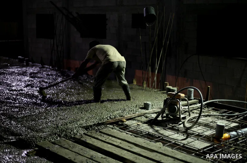 Palestinian construction workers work in Shajaiyeh neighborhood in Gaza city, on June 18, 2016. Palestinian construction workers work during the night in the month of Ramadan because of the high temperatures they can not...