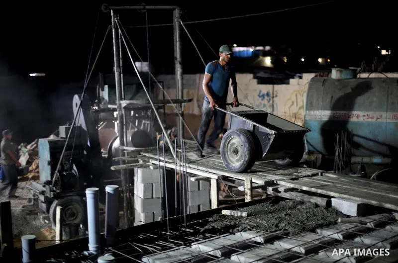 Palestinian construction workers work in Shajaiyeh neighborhood in Gaza city, on June 18, 2016. Palestinian construction workers work during the night in the month of Ramadan because of the high temperatures they can not...