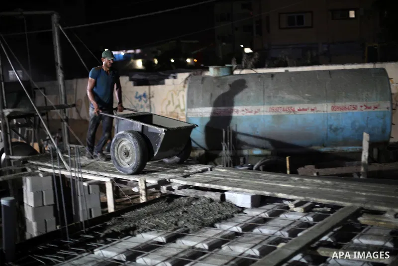 Palestinian construction workers work in Shajaiyeh neighborhood in Gaza city, on June 18, 2016. Palestinian construction workers work during the night in the month of Ramadan because of the high temperatures they can not...