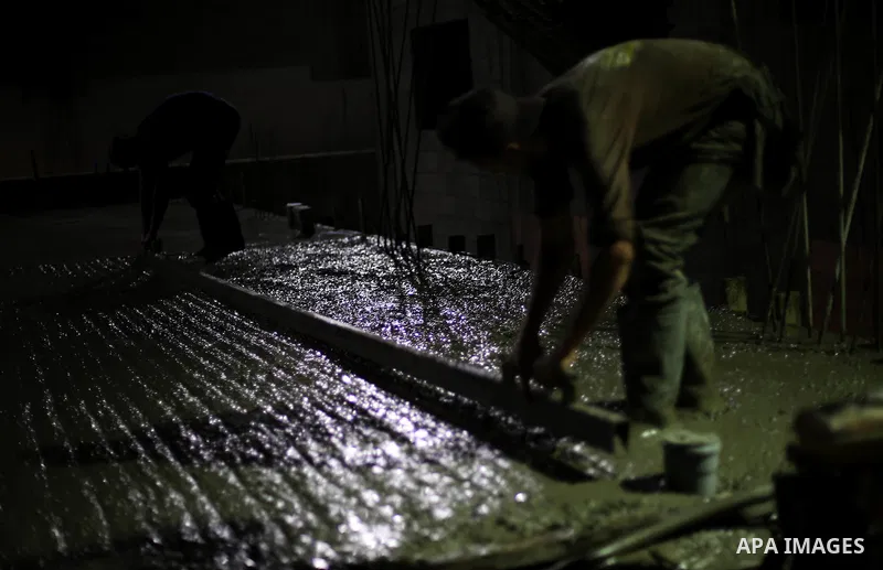 Palestinian construction workers work in Shajaiyeh neighborhood in Gaza city, on June 18, 2016. Palestinian construction workers work during the night in the month of Ramadan because of the high temperatures they can not...