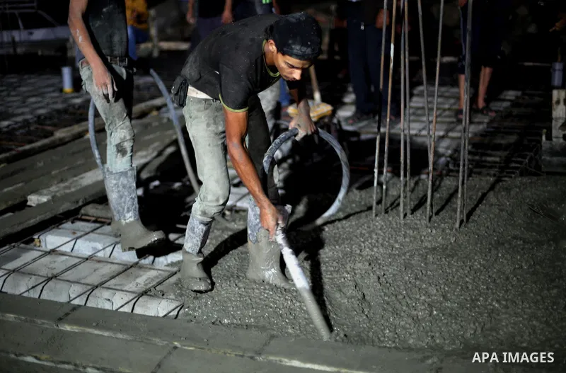 Palestinian construction workers work in Shajaiyeh neighborhood in Gaza city, on June 18, 2016. Palestinian construction workers work during the night in the month of Ramadan because of the high temperatures they can not...