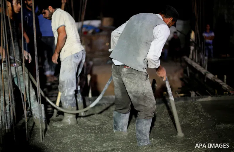 Palestinian construction workers work in Shajaiyeh neighborhood in Gaza city, on June 18, 2016. Palestinian construction workers work during the night in the month of Ramadan because of the high temperatures they can not...