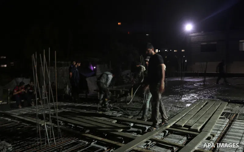 Palestinian construction workers work in Shajaiyeh neighborhood in Gaza city, on June 18, 2016. Palestinian construction workers work during the night in the month of Ramadan because of the high temperatures they can not...