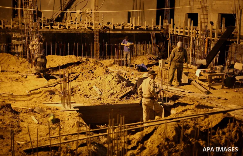 Palestinian construction workers work in Shajaiyeh neighborhood in Gaza city, on June 18, 2016. Palestinian construction workers work during the night in the month of Ramadan because of the high temperatures they can not...