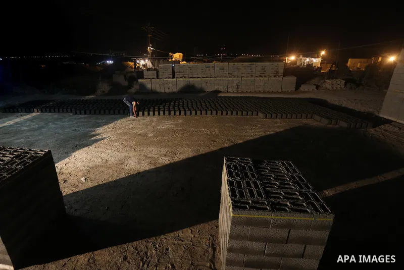 Palestinian construction workers work in Shajaiyeh neighborhood in Gaza city, on June 18, 2016. Palestinian construction workers work during the night in the month of Ramadan because of the high temperatures they can not...