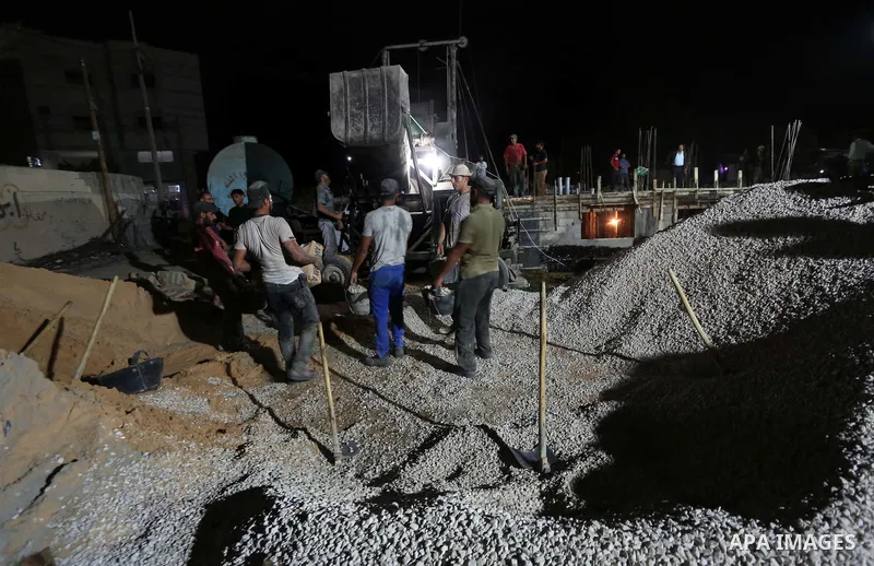 Palestinian construction workers work in Shajaiyeh neighborhood in Gaza city, on June 18, 2016. Palestinian construction workers work during the night in the month of Ramadan because of the high temperatures they can not...