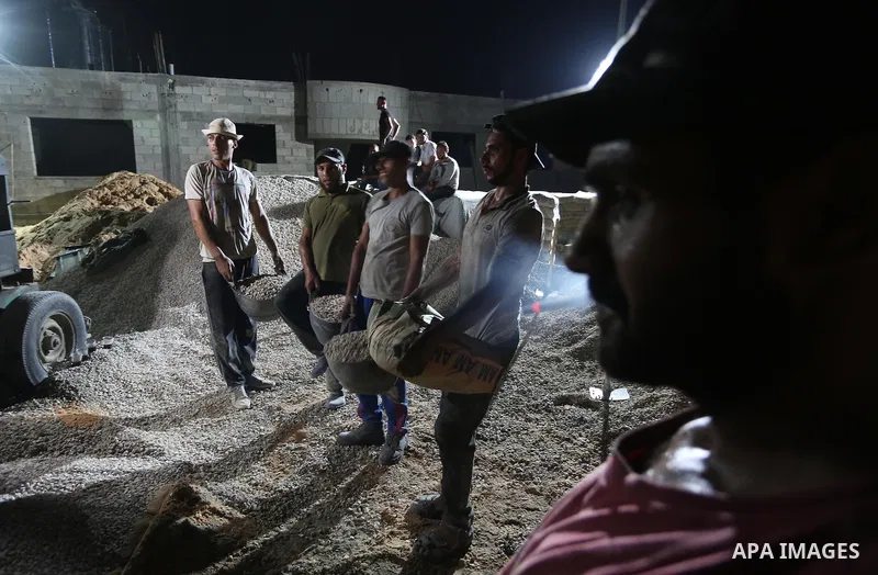 Palestinian construction workers work in Shajaiyeh neighborhood in Gaza city, on June 18, 2016. Palestinian construction workers work during the night in the month of Ramadan because of the high temperatures they can not...