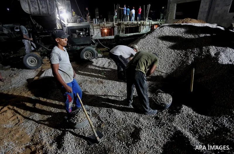 Palestinian construction workers work in Shajaiyeh neighborhood in Gaza city, on June 18, 2016. Palestinian construction workers work during the night in the month of Ramadan because of the high temperatures they can not...