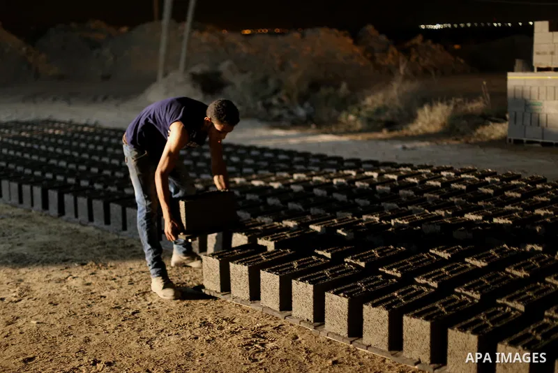 Palestinian construction workers work in Shajaiyeh neighborhood in Gaza city, on June 18, 2016. Palestinian construction workers work during the night in the month of Ramadan because of the high temperatures they can not...