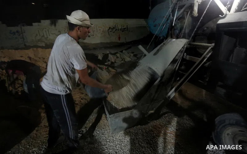 Palestinian construction workers work in Shajaiyeh neighborhood in Gaza city, on June 18, 2016. Palestinian construction workers work during the night in the month of Ramadan because of the high temperatures they can not...