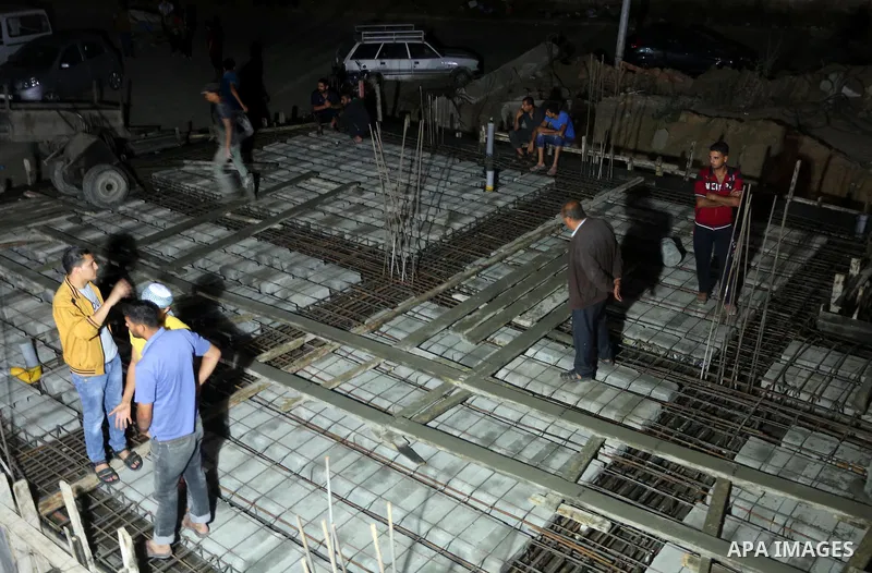 Palestinian construction workers work in Shajaiyeh neighborhood in Gaza city, on June 18, 2016. Palestinian construction workers work during the night in the month of Ramadan because of the high temperatures they can not...