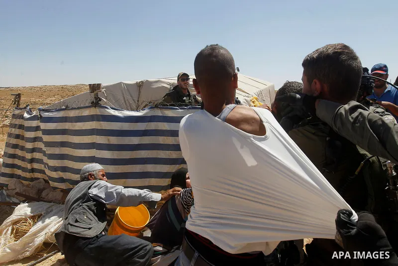 Israeli border policemen push away a Palestinian man as Israeli troops demolish sheds belonging to Palestinians near the West Bank village of Yatta, south of Hebron June 19, 2016. Photo by Wisam Hashlamoun
