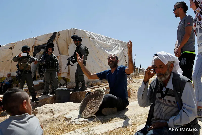 A Palestinian man reacts as Israeli troops demolish sheds belonging to Palestinians near the West Bank village of Yatta, south of Hebron June 19, 2016. Photo by Wisam Hashlamoun