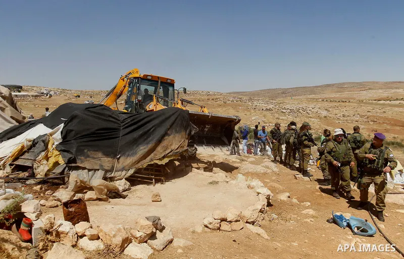 Israeli soldiers stand guard as Israeli troops demolish sheds belonging to Palestinians near the West Bank village of Yatta, south of Hebron June 19, 2016. Photo by Wisam Hashlamoun